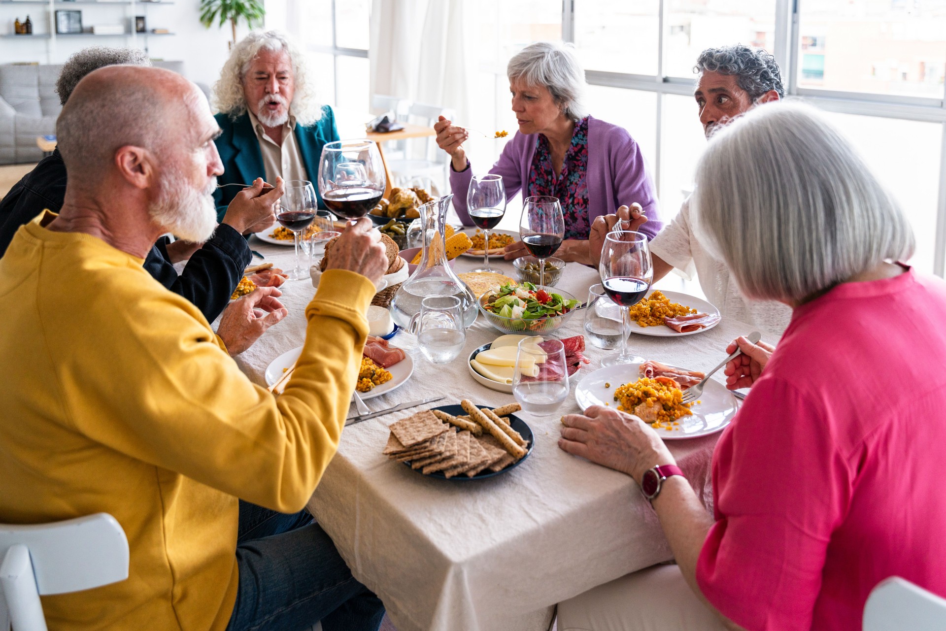 Group of senior friends bonding at home for dinner party